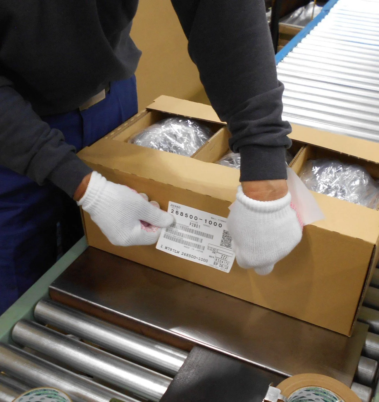 検査用の作業台で部品と記録票を確認するスタッフの手元